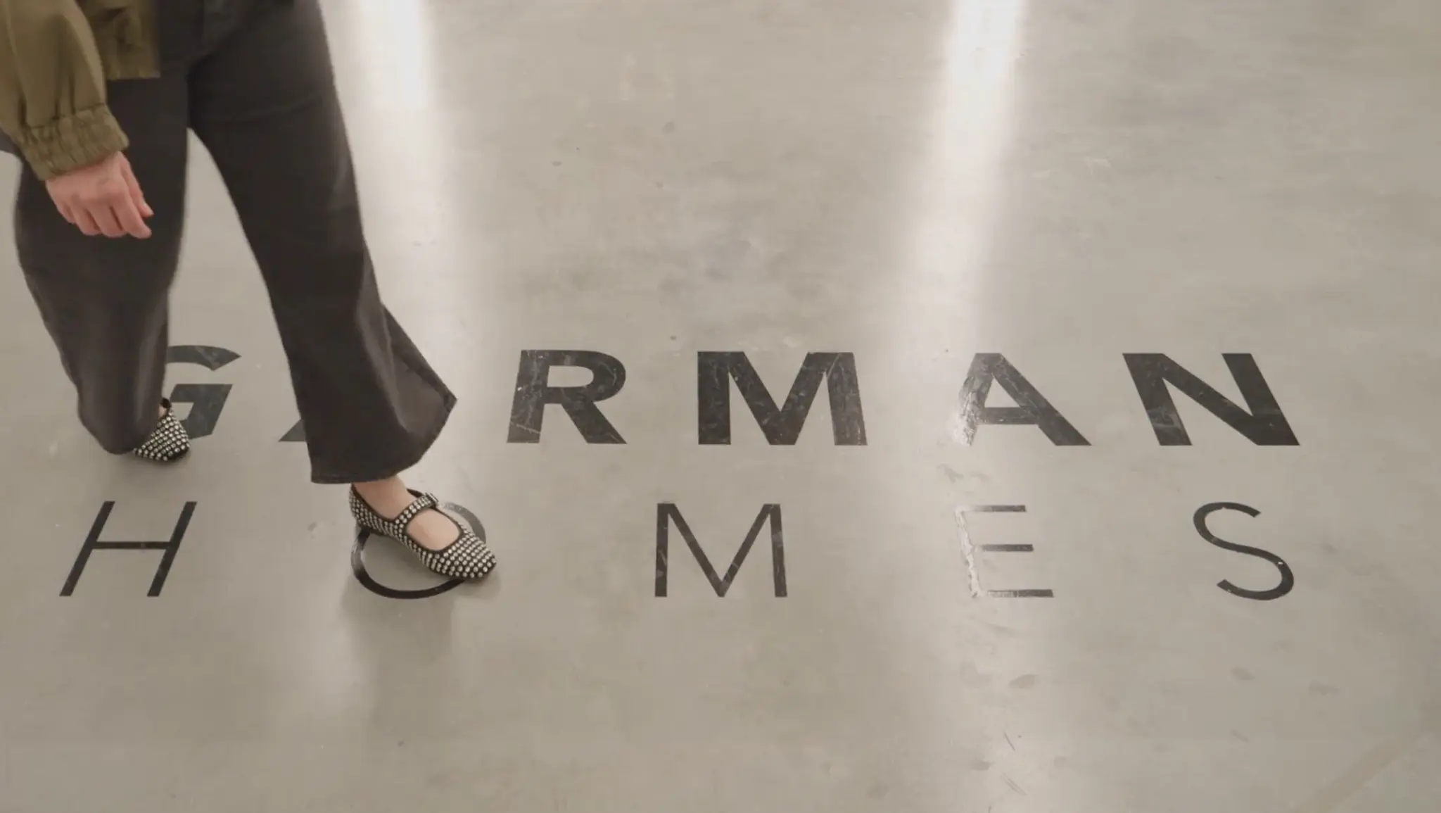 Woman walking on Garman Homes logo