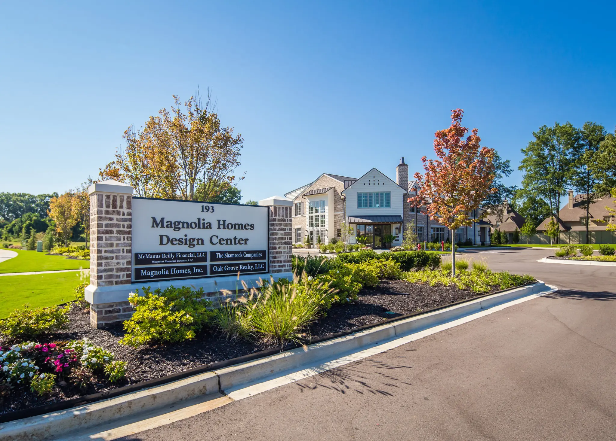 Magnolia Homes Design Center welcome sign with fruitful vegetation.