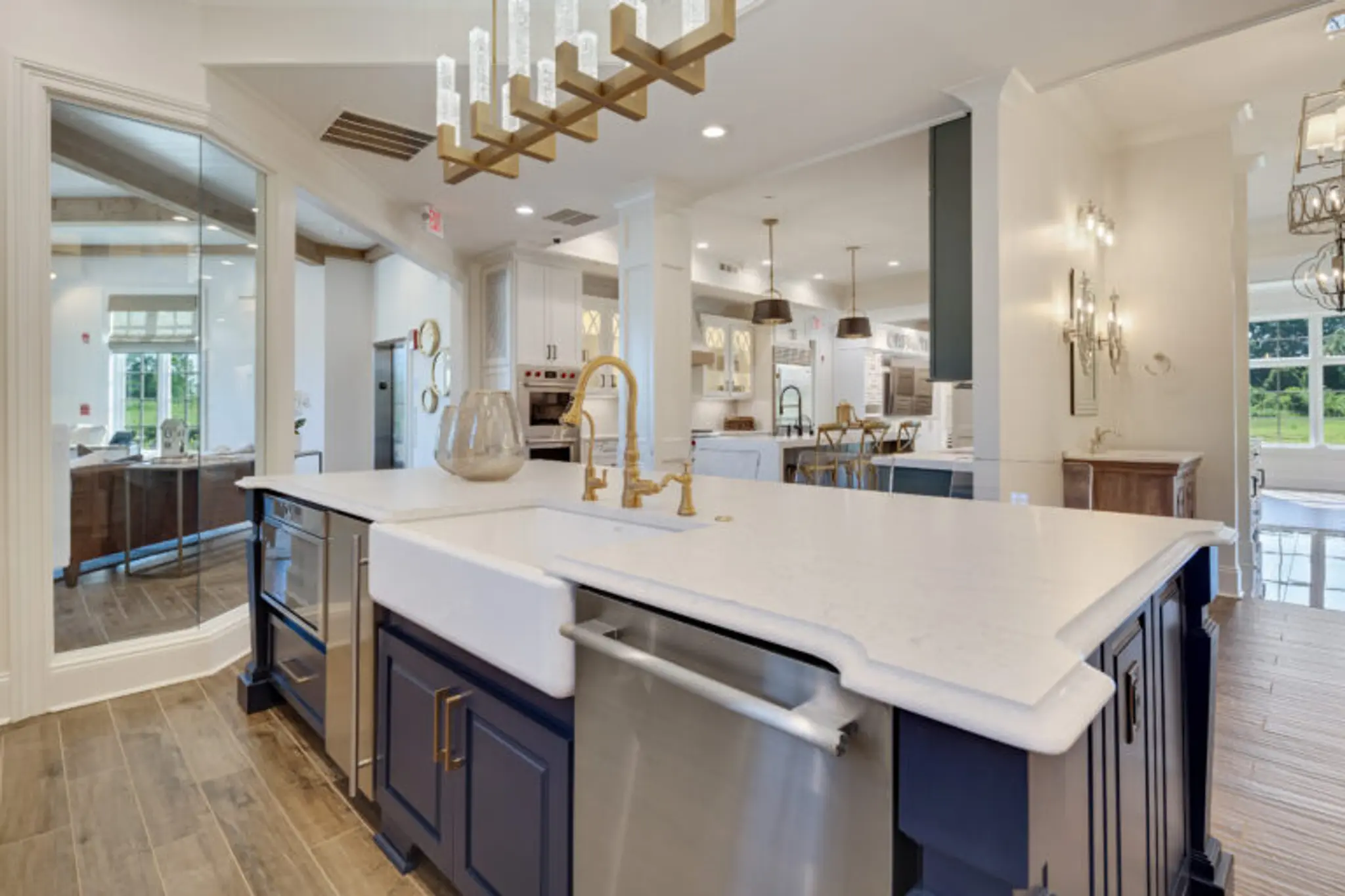 Navy blue kitchen island with silestone countertops, gold plumbing fixtures, and stunning light fixtures