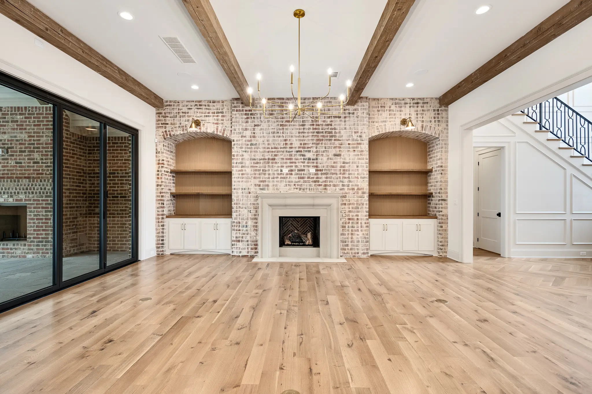 Family room built-in with slurried brick, cedar beams, and reeded backdrop over floating open shelves