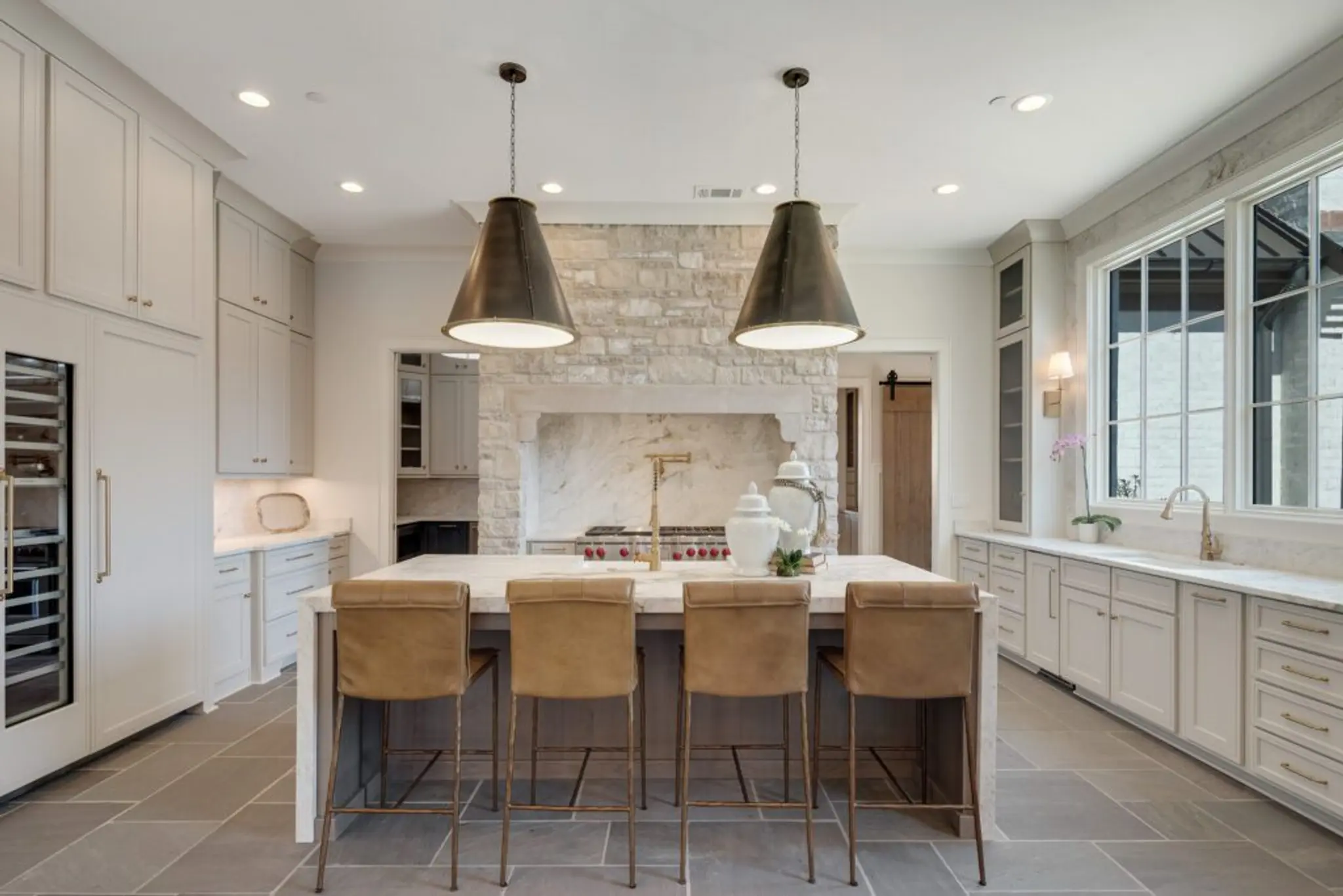 Beautifully-crafted Magnolia Homes kitchen with timeless stone floors and vent hood