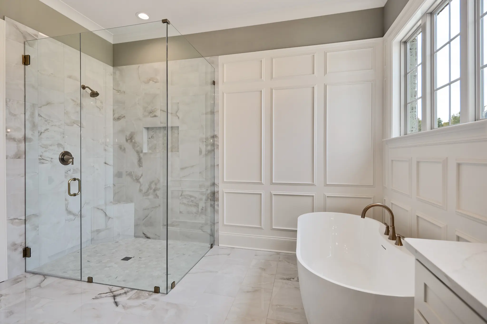Luxurious new construction bathroom with bathtub and glass shower