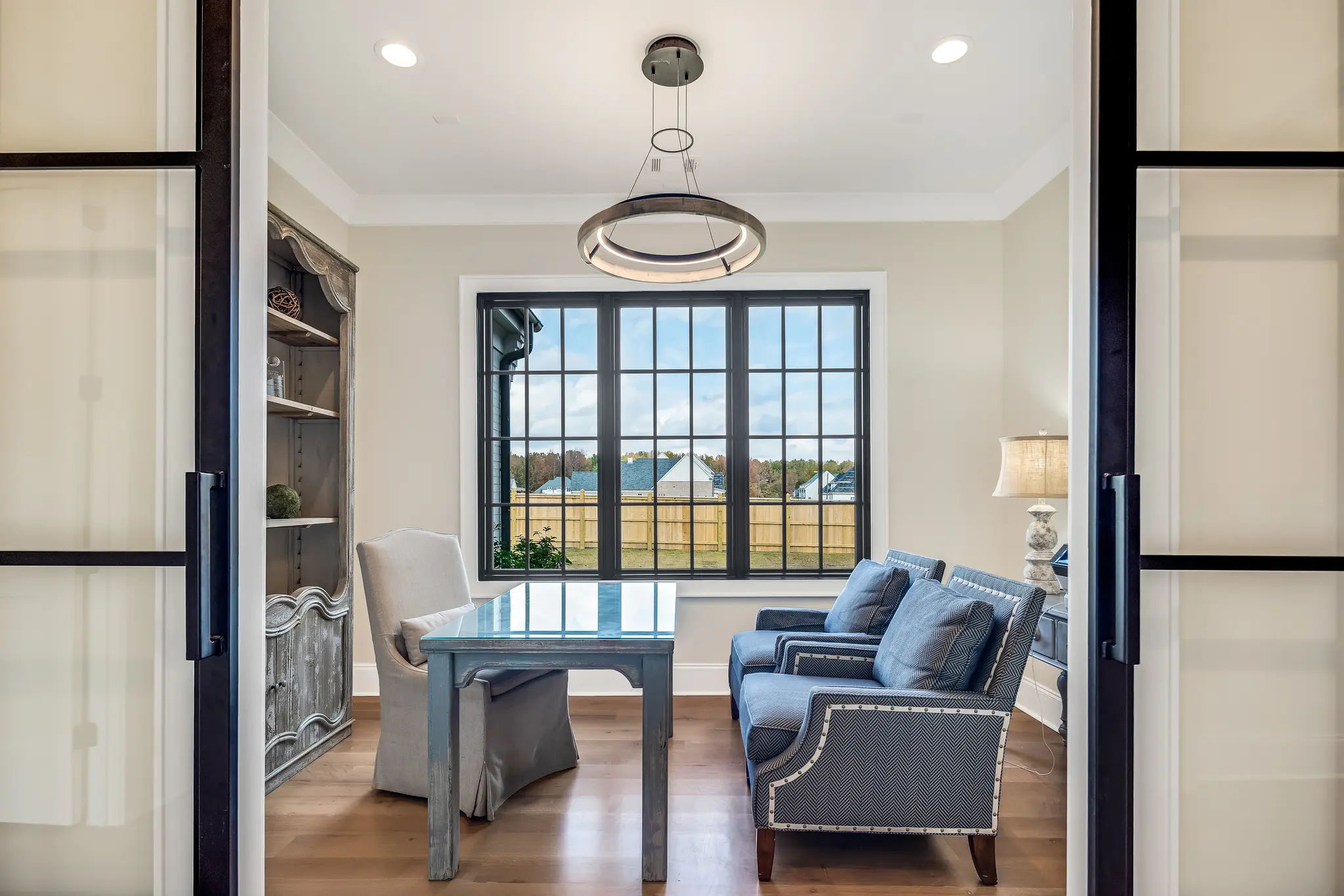 Home office with gorgeous black metal iron doors and a smart statement light fixture