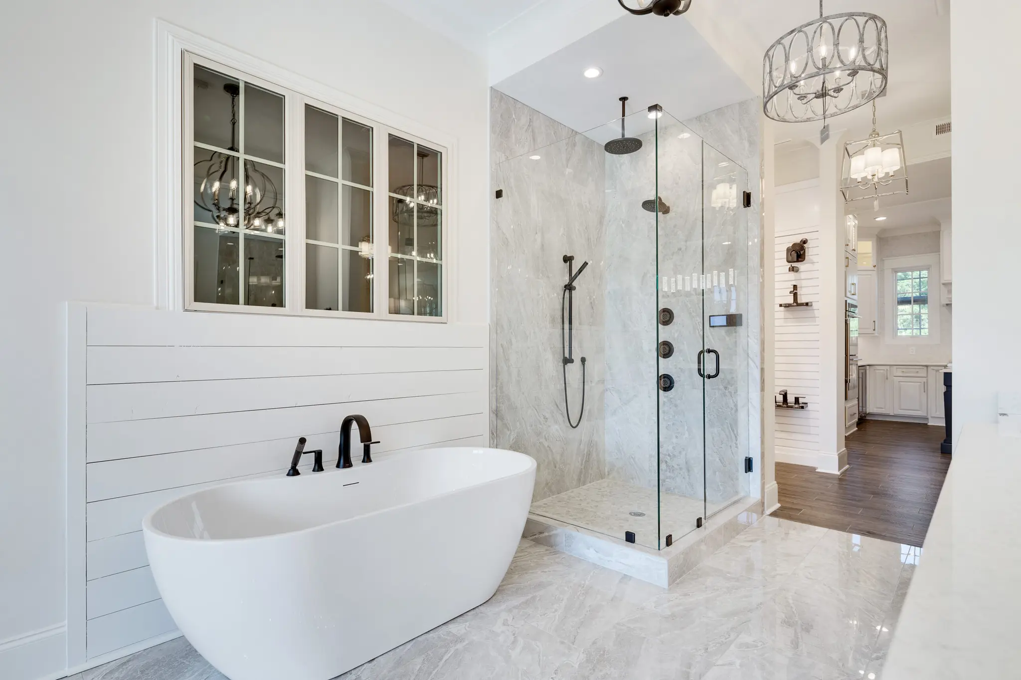 Magnolia Homes Design Center with glass enclosed shower, soaking tub, luxurious tile, and trim work examples.