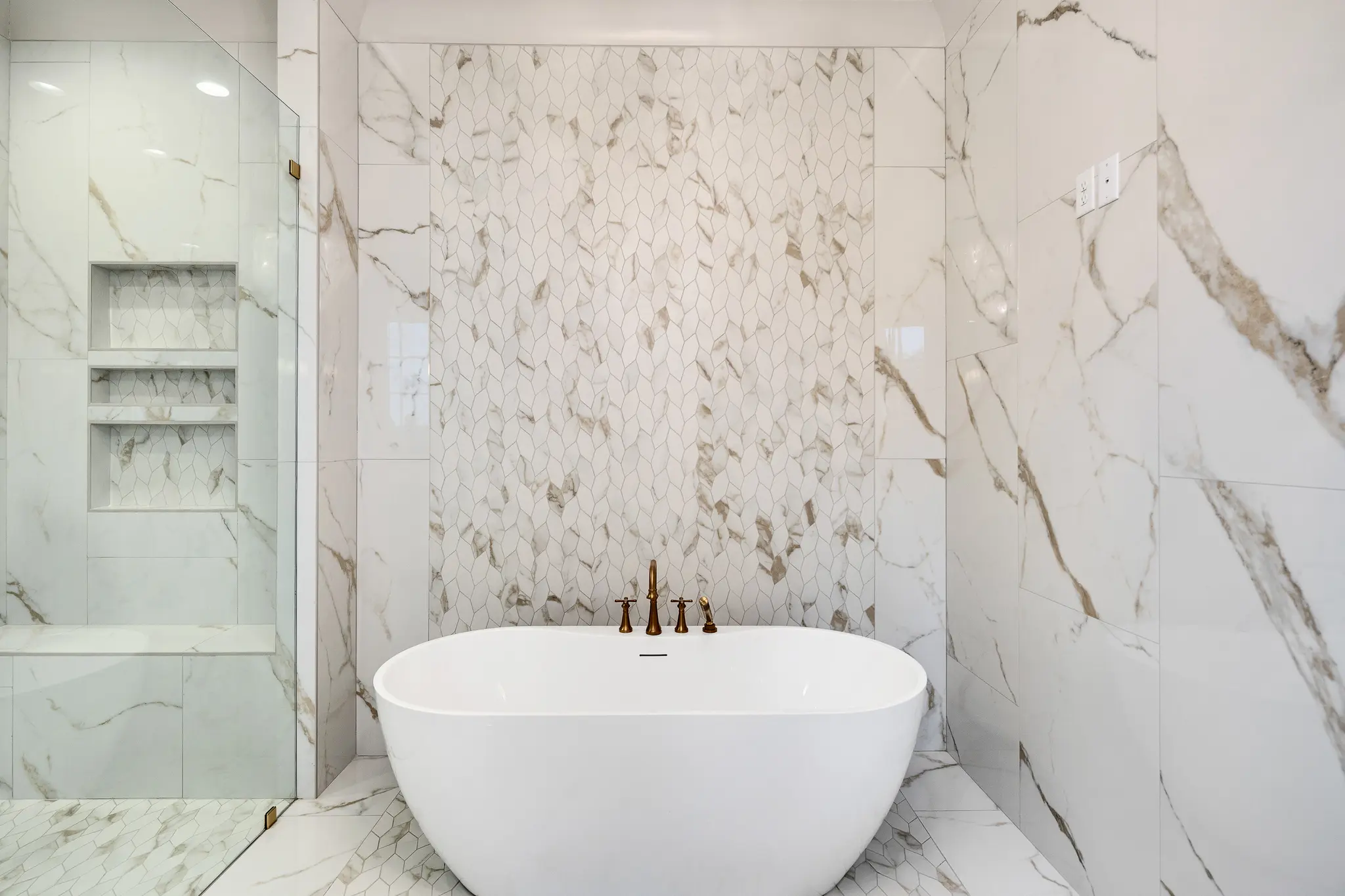 Sizable soaking tub in luxury bathroom with stunning marble tile surround