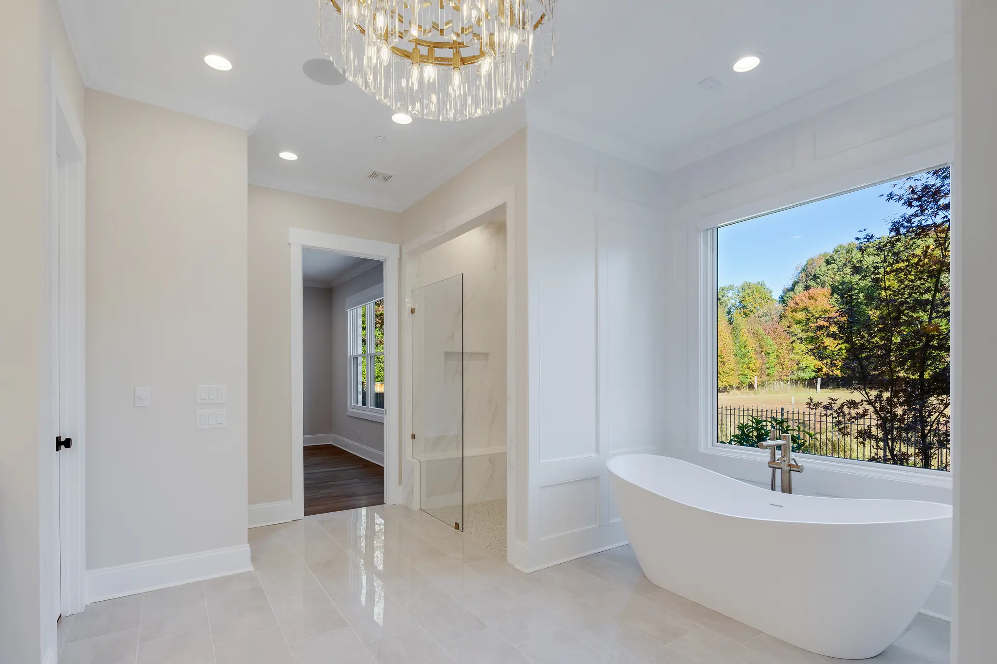 Gorgeous primary bathroom soaking tub overlooking scenic farm in the Fall