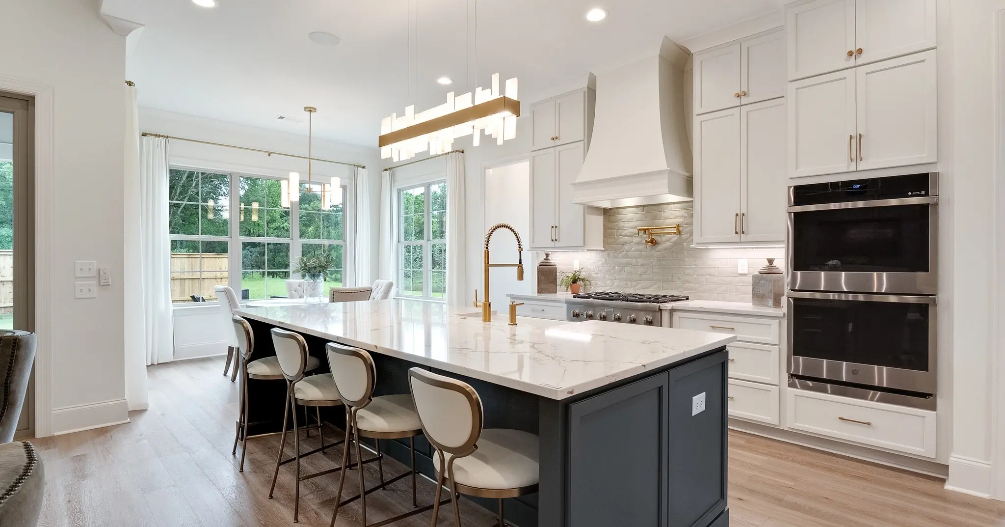 quality-built kitchen with a state-of-the-art island, double convection ovens, captivating quartz, and statement light fixtures