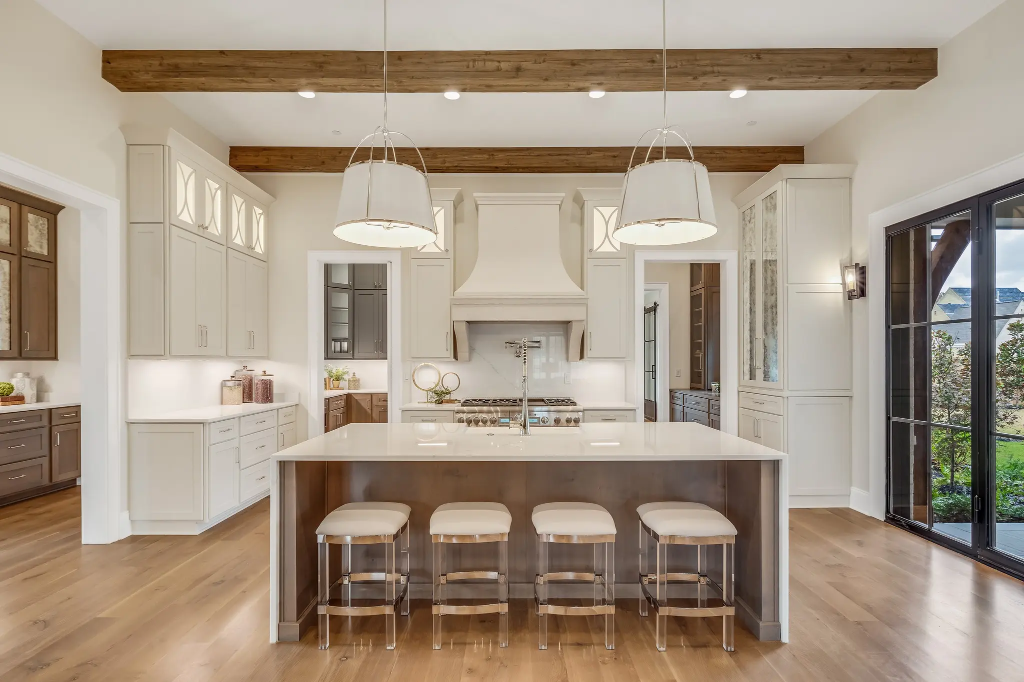 Gleaming Magnolia Homes kitchen with pendant lights, wood island, glossy countertops, and white cabinetry.