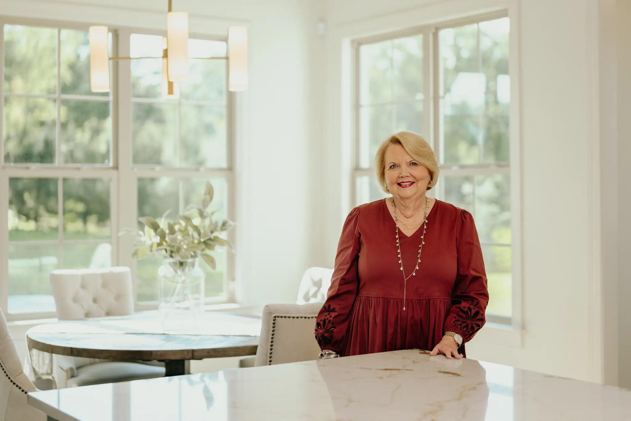 Ms. Karen Garner standing in a bright Magnolia Kitchen and breakfast room